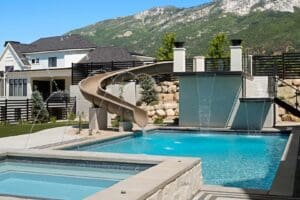 Backyard pool with slide and mountain view.